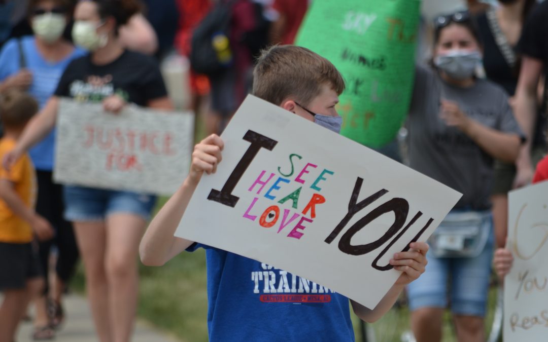 Little boy holding a sign, " I see you, I hear you, I love you"